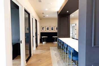 A long hallway with a table and chairs at the end at The Crest at South Point Apartments, Davenport , Georgia